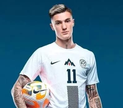 Jugador sosteniendo balón en uniforme blanco
