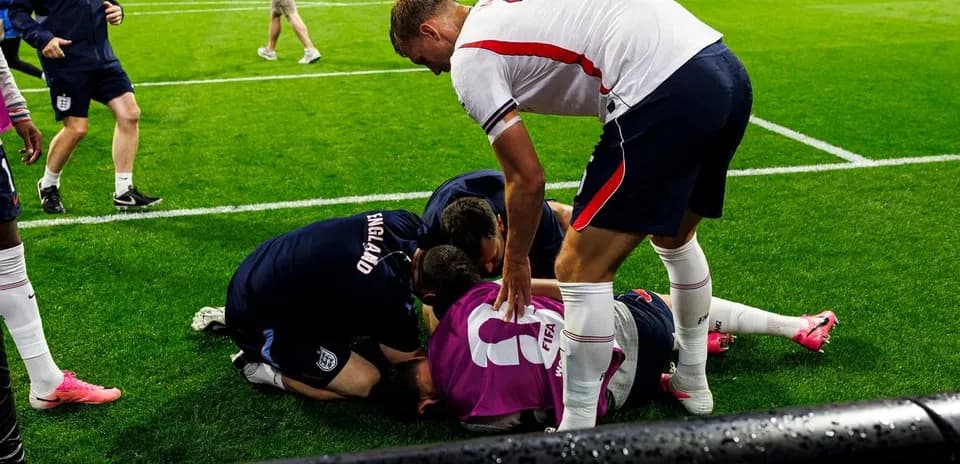 Jugadores y personal ayudando a un compañero caído