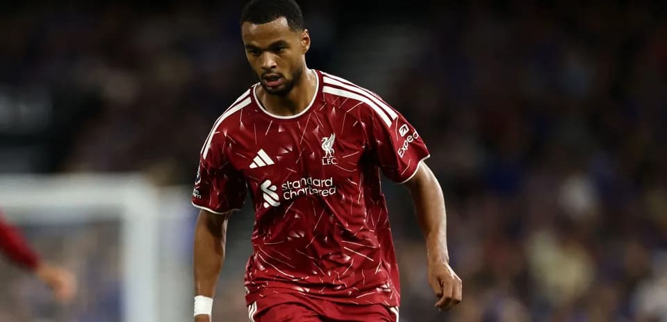 Jugador de Liverpool corriendo con balón en el campo