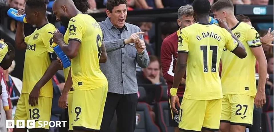 Entrenador dando instrucciones a los jugadores en banquillo