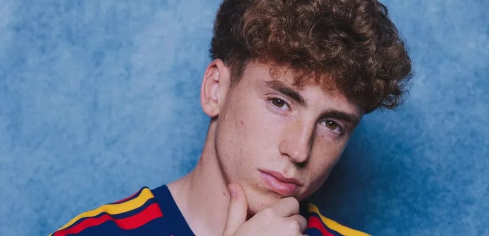 Joven con camiseta de rayas frente a fondo azul