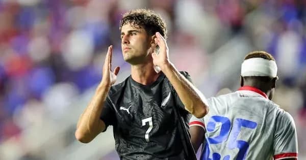 Jugador con camiseta negra gesticulando en el campo