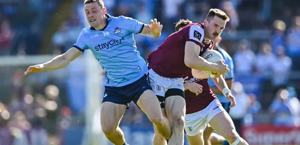 Jugador de Galway llevando el balón mientras es tackleado