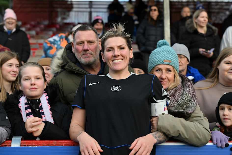 Jugadora sonriendo con aficionados en el estadio