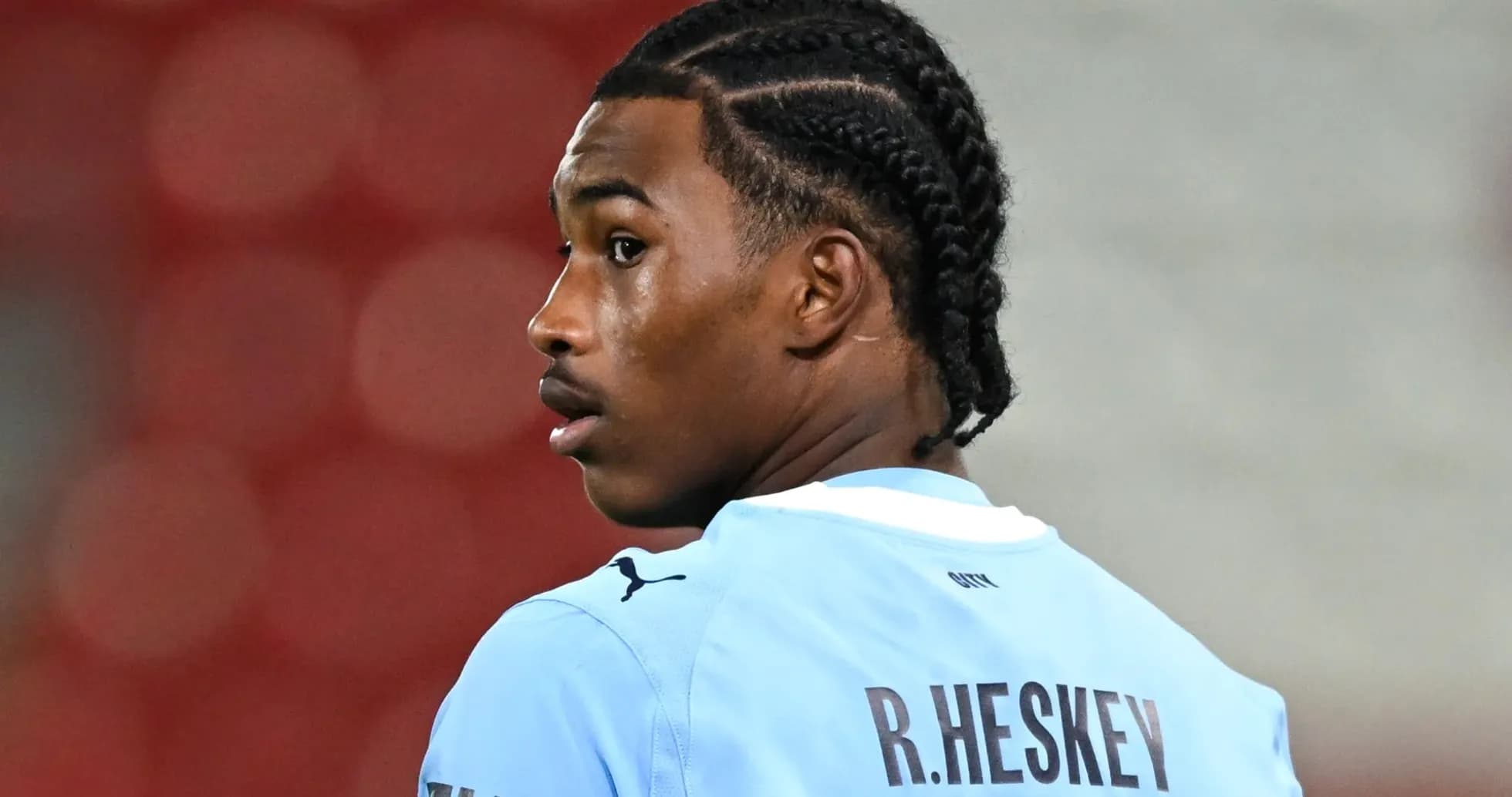 Jugador con trenzas en uniforme azul mirando hacia atrás