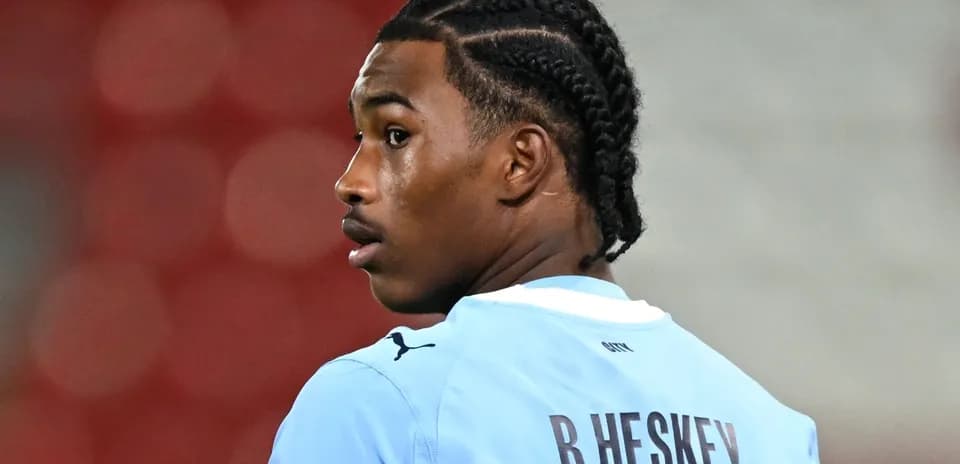 Jugador con trenzas en uniforme azul mirando hacia atrás