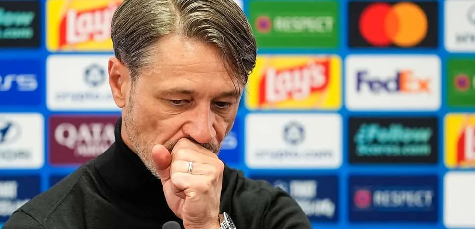 Entrenador en conferencia de prensa con logos de patrocinadores