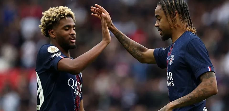 Dos jugadores de PSG chocando las manos en el campo