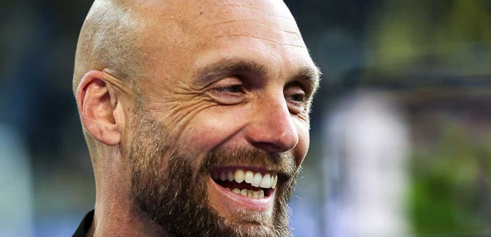 Hombre sonriendo con barba en un evento deportivo
