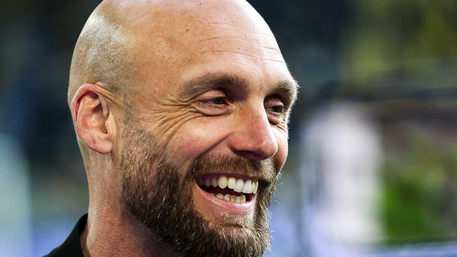 Hombre sonriendo con barba en un evento deportivo