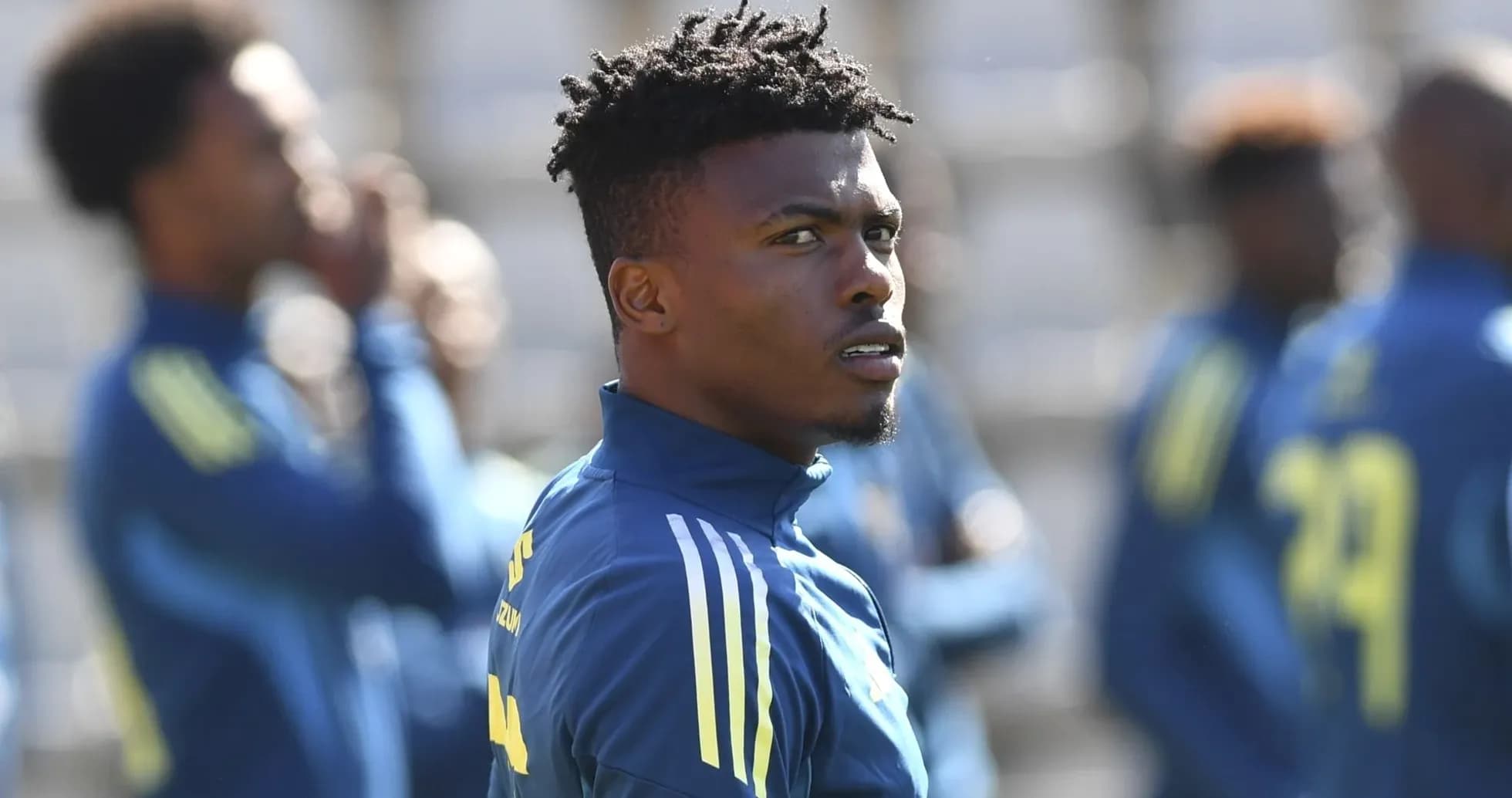 Jugador entrenando con equipo en campo de fútbol
