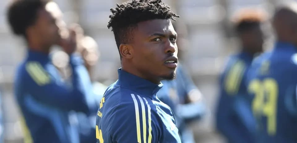 Jugador entrenando con equipo en campo de fútbol