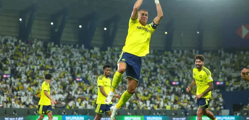 Jugador saltando con compañeros en el estadio