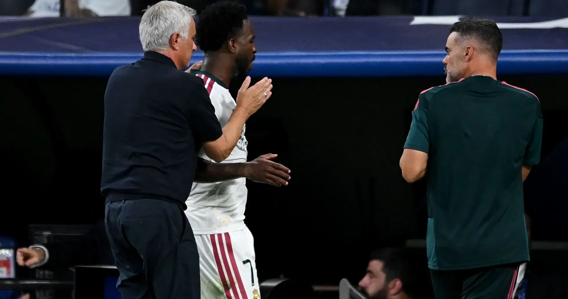 Entrenador hablando con jugador en el banquillo