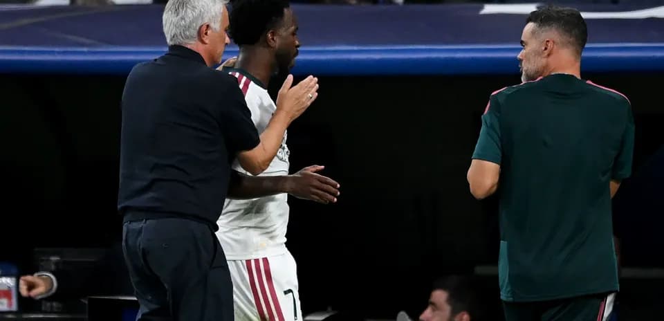 Entrenador hablando con jugador en el banquillo