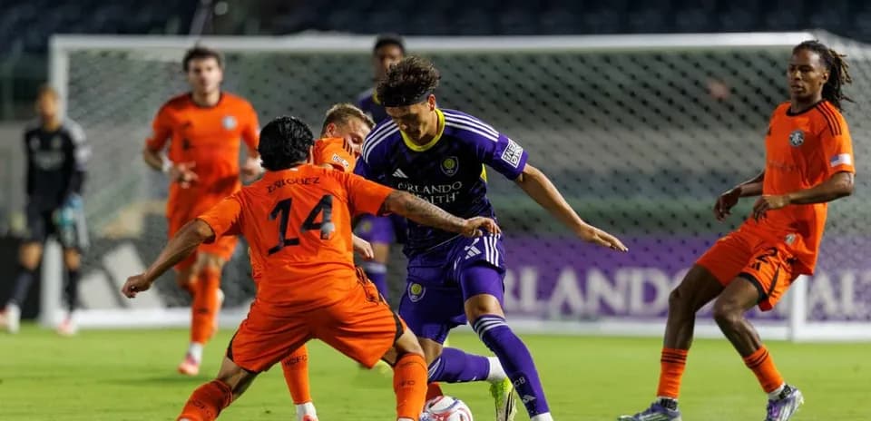 Enriquez y jugador de Orlando City en acción