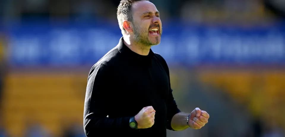 Entrenador celebrando durante un partido en el campo