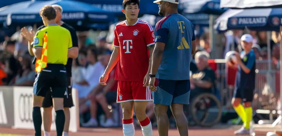 Jugador de Bayern Munich hablando con entrenador durante partido