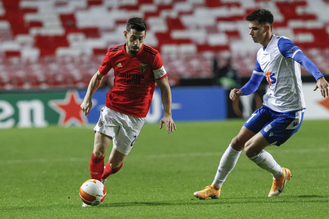 Jugador de Benfica driblando a rival de Lech Poznan