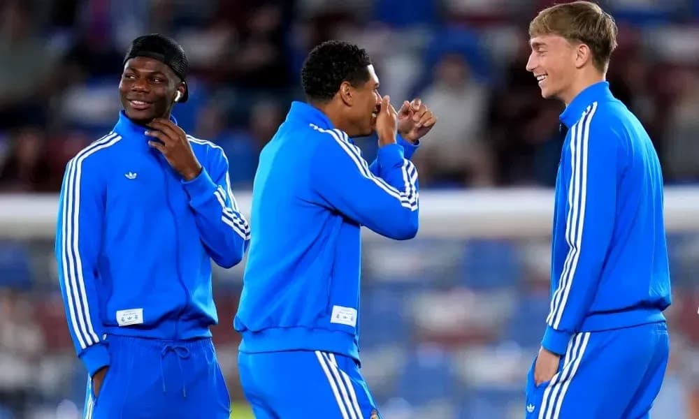 Tres jugadores en calentamiento riendo y conversando