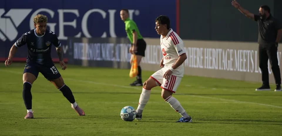 Jugador driblando durante el partido de fútbol