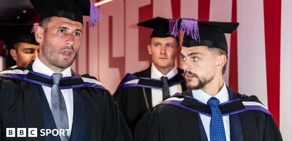Tres graduados con togas y birretes conversando