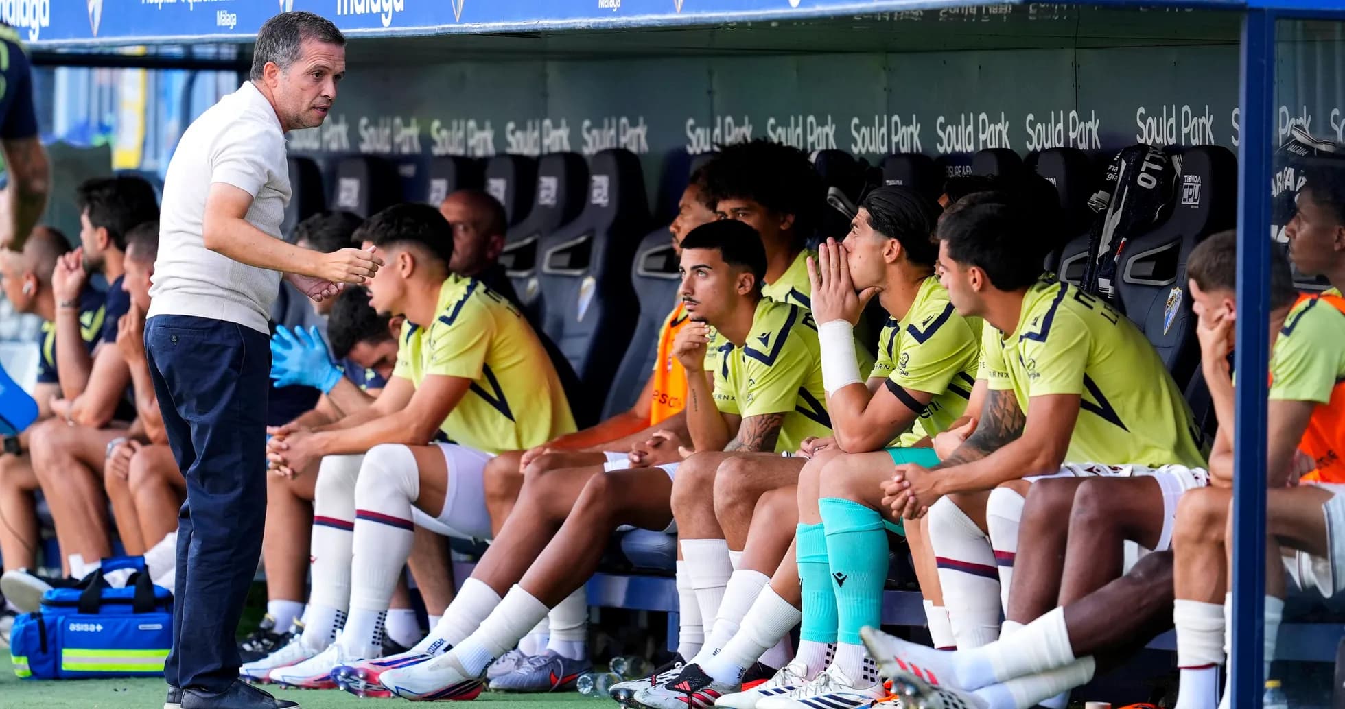 Entrenador hablando con jugadores en el banquillo
