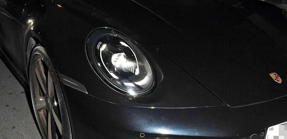 Dos personas dentro de un Porsche deportivo en la noche