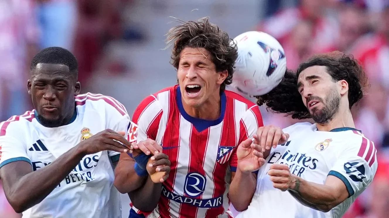 Jugadores de Atlético y Real Madrid luchando por el balón