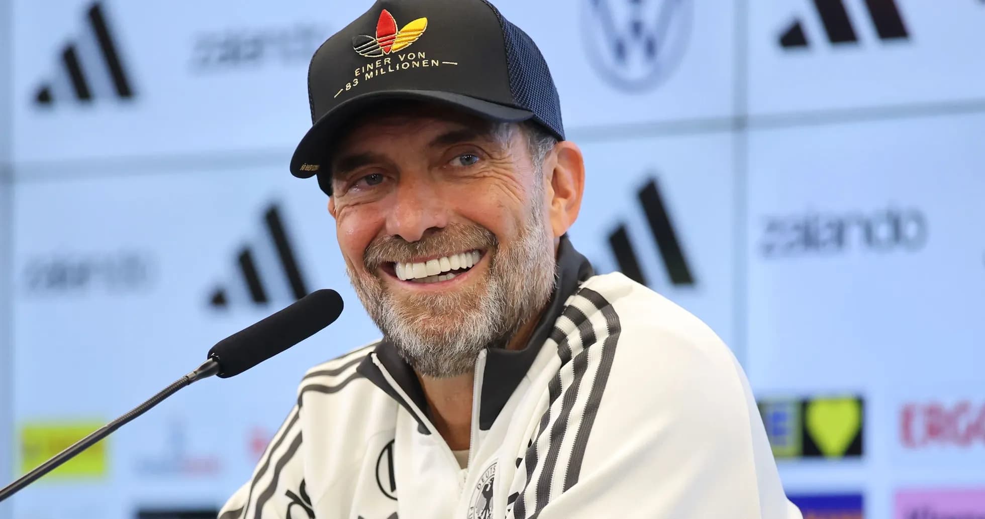 Entrenador sonriente en rueda de prensa
