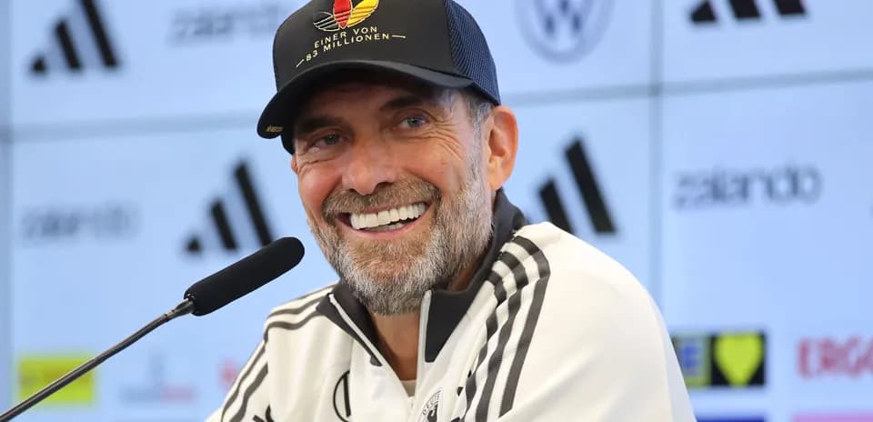 Entrenador sonriente en rueda de prensa