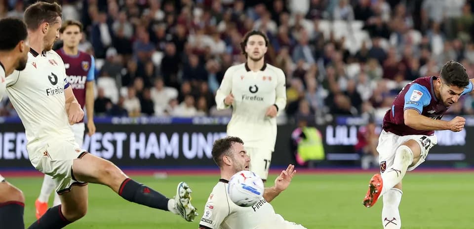 Jugador de West Ham disparando mientras un rival cae