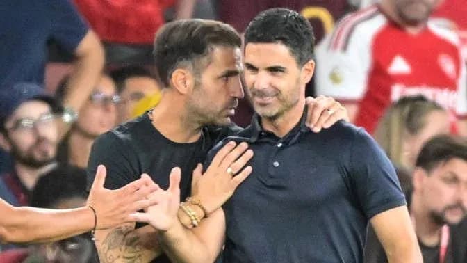 Entrenadores conversando durante un partido de fútbol