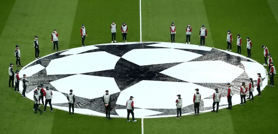 Personal organizando el balón de la Champions League
