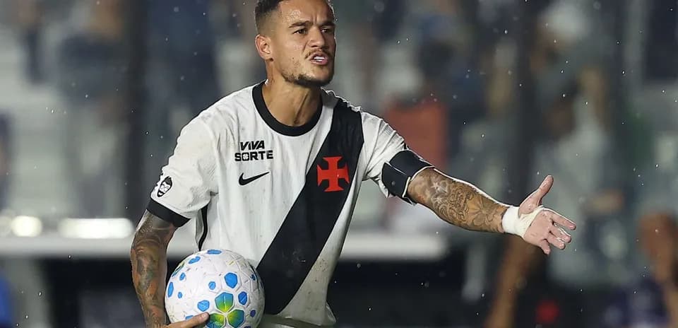 Jugador de fútbol sosteniendo un balón y señalando