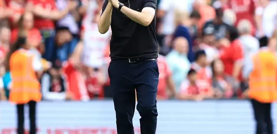 Entrenador aplaudiendo a los aficionados en el estadio
