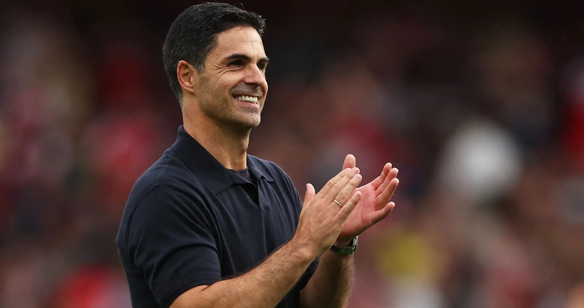Entrenador aplaudiendo en el campo durante partido