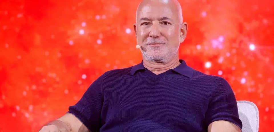 Persona sentado en un escenario con fondo rojo