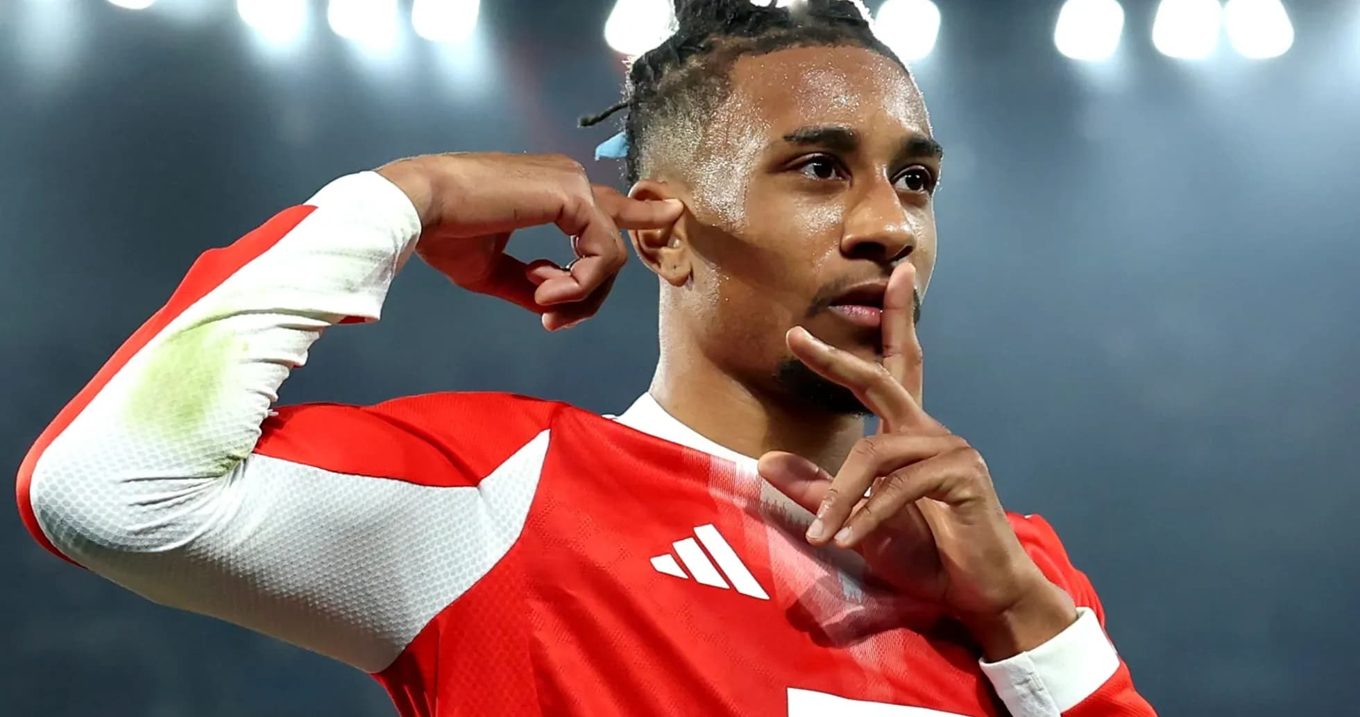 Jugador con camiseta roja haciendo gesto de silencio