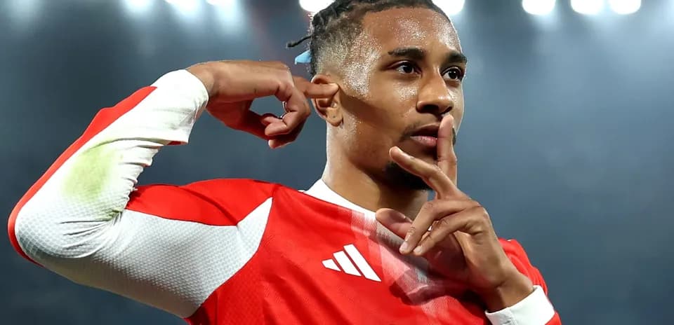 Jugador con camiseta roja haciendo gesto de silencio