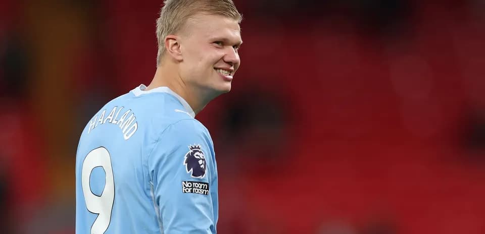 Jugador sonriendo con camiseta azul en el campo