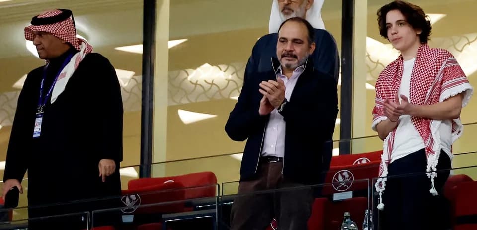 Cuatro hombres aplaudiendo en un palco de estadio