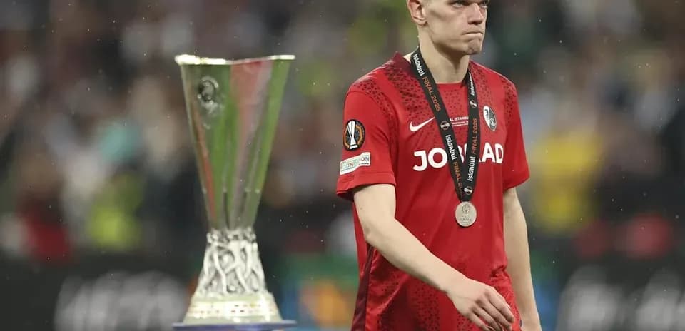 Jugador con medalla, caminando junto a trofeo UEFA