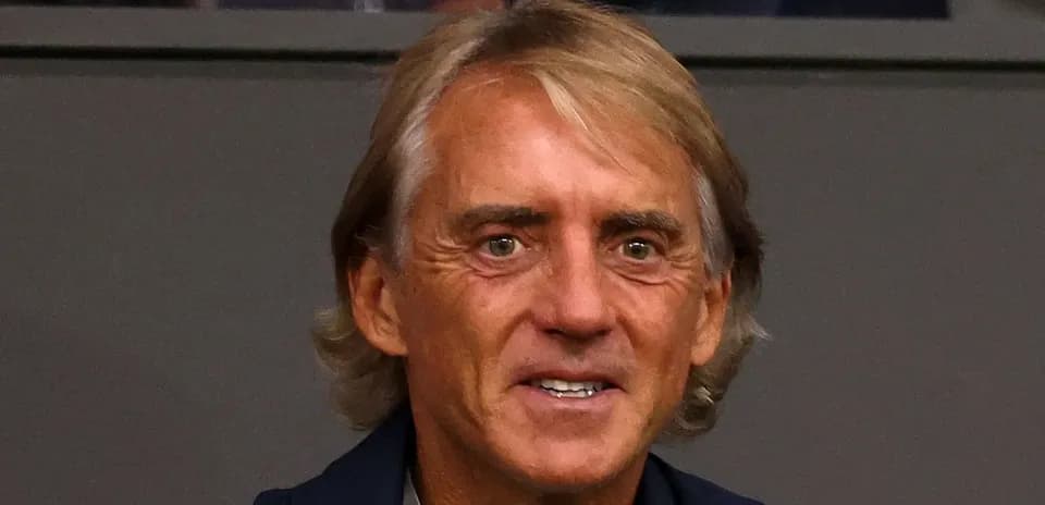 Hombre con cabello rubio sentado en un estadio