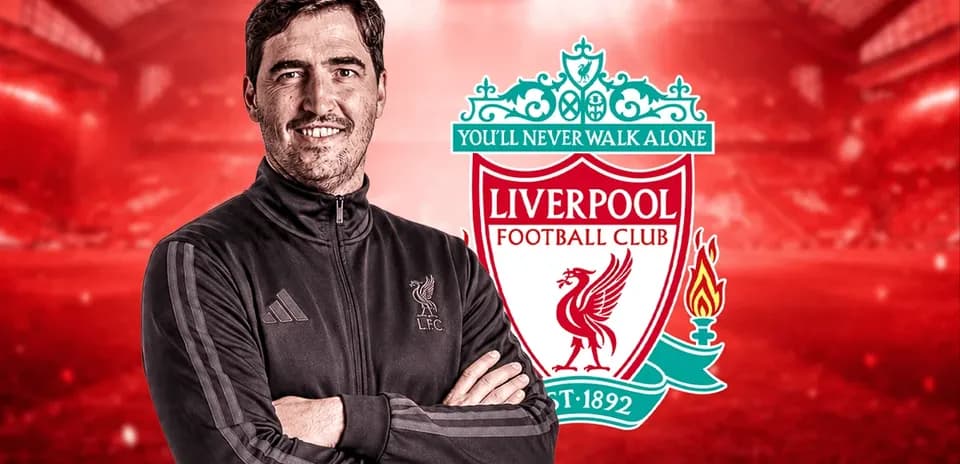 Entrenador posando frente al escudo de Liverpool FC