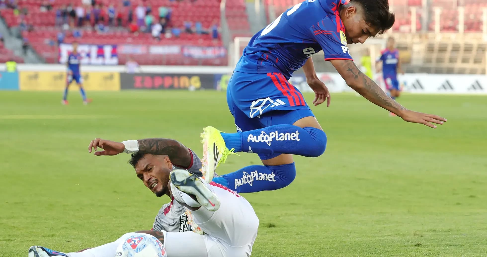 Jugador de Universidad de Chile saltando sobre rival