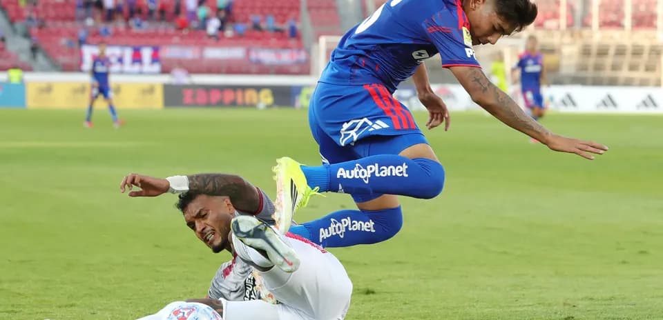 Jugador de Universidad de Chile saltando sobre rival