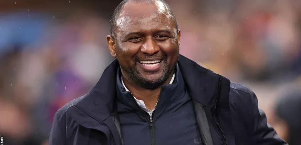 Entrenador sonriente en el campo durante un partido