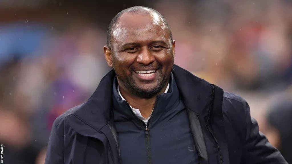 Entrenador sonriente en el campo durante un partido
