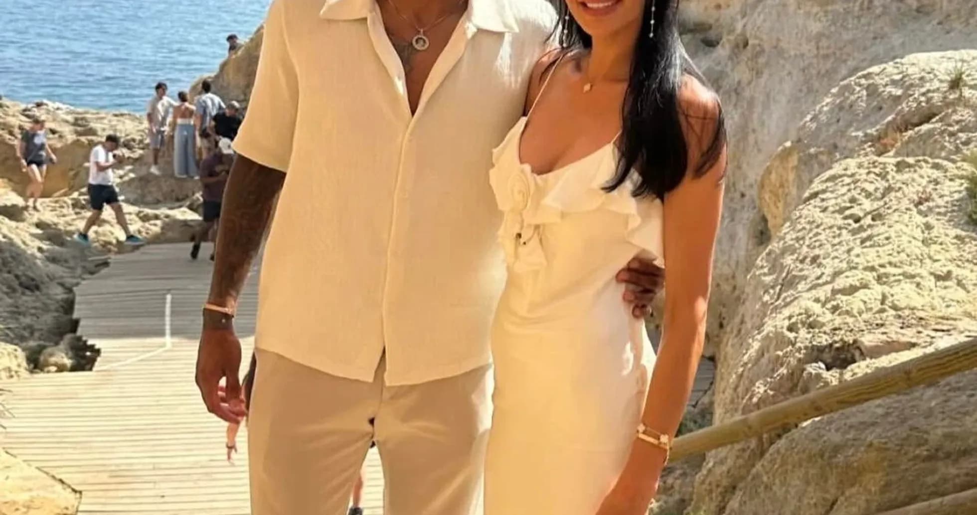 Pareja posando junto a la costa en un día soleado